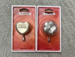 New Creuset Stainless Steel Heart Knob(light Gold) & Flower Silver. Price: $75.00.
